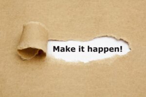 Torn paper revealing the words “Make it happen!”