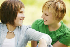 Two smiling women talking outdoors